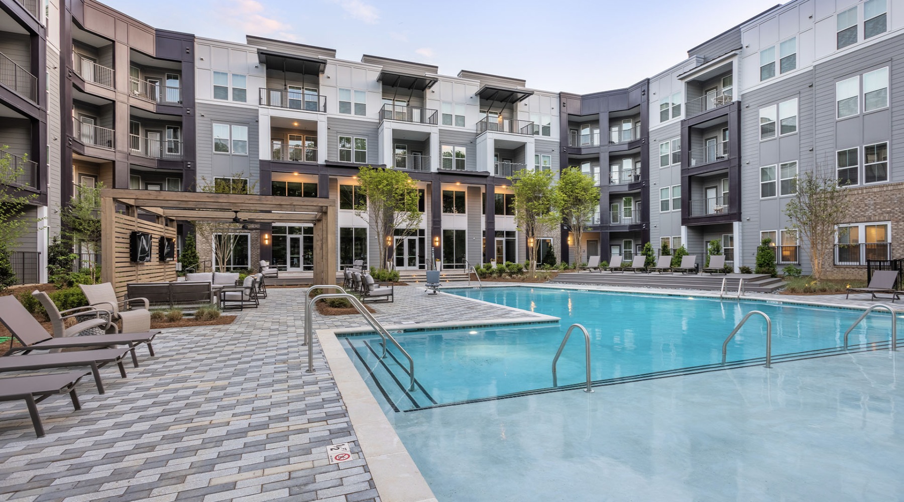 Resort-style swimming pool with sundeck, lounge chairs, and cabana seating at Velo Circleport